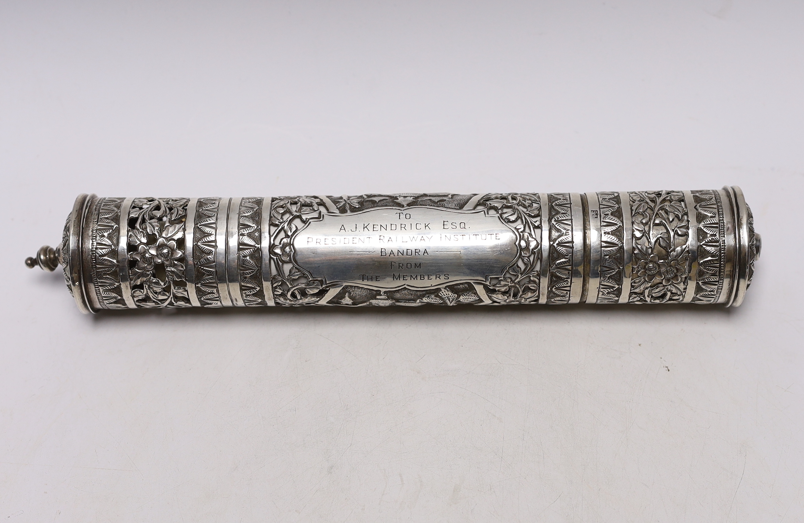 A mid 20th century Indian pierced white metal presentation scroll case to 'To A.J. Kendrick Esq. President Railway Institute Bandra, From The Members', 31.7cm, containing a silk scroll dedicated to the recipient